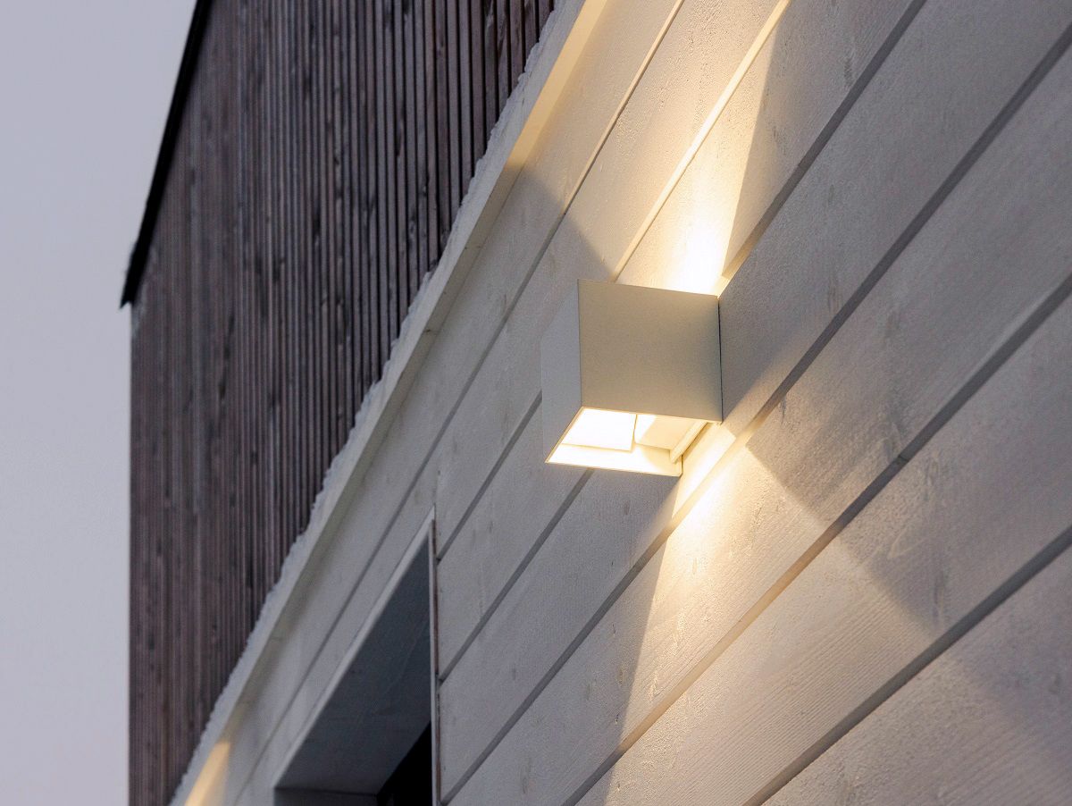 Close-up of a white FUNK wall light on an exterior wall.